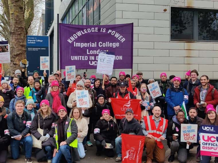 Une grande ligne de piquetage à l'extérieur de l'Imperial College de Londres.  Les grévistes portent des chapeaux UCU roses ou des gilets Unite rouges.