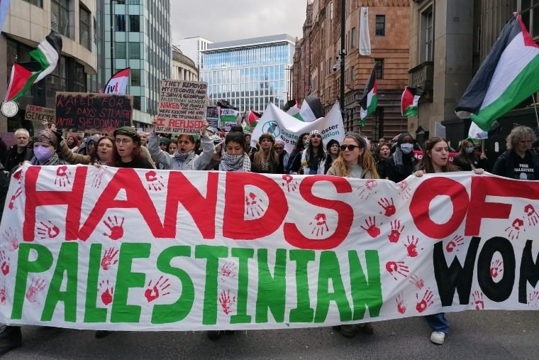 les gens tiennent une banderole sur la manifestation palestinienne à Manchester 