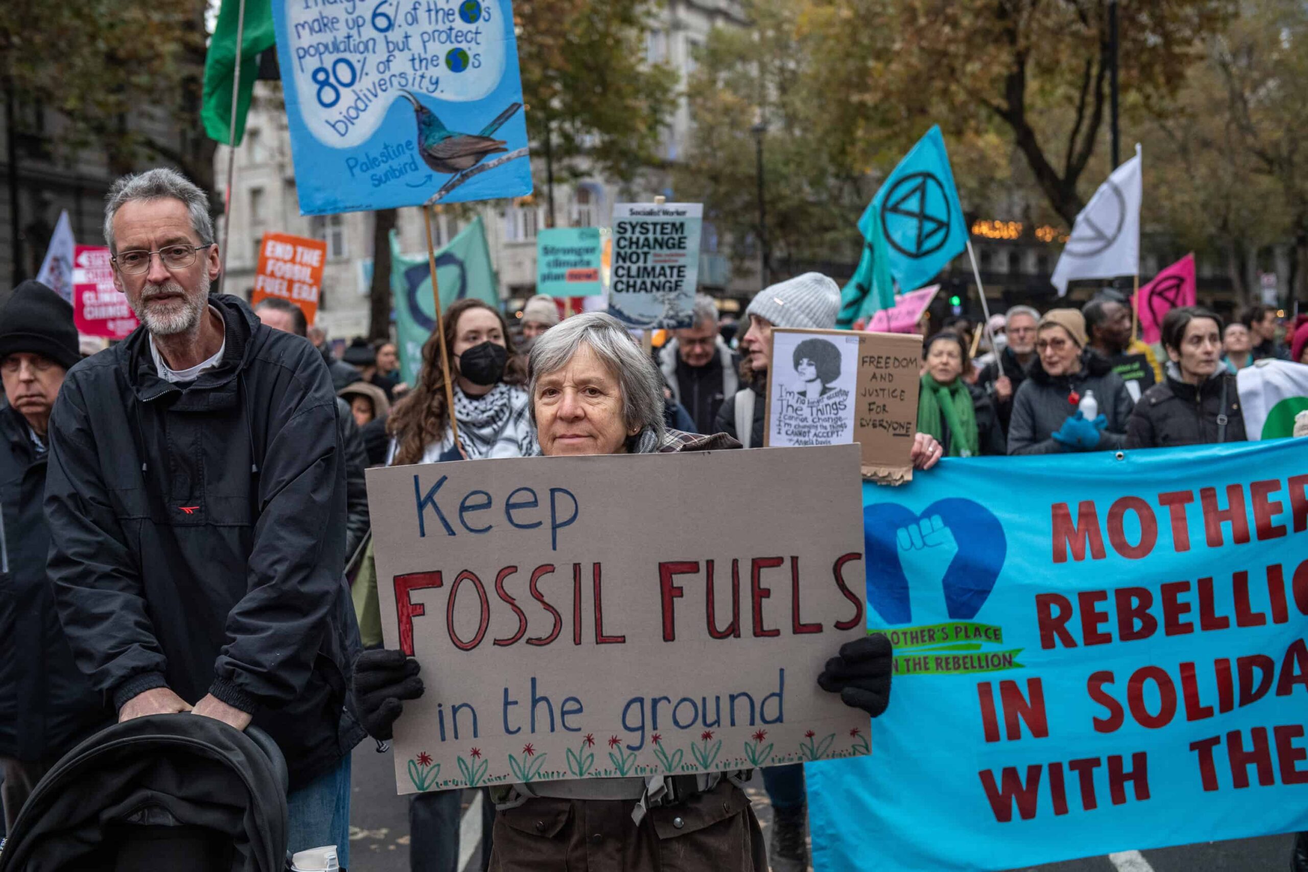 A crowd shot of a demo with a placard that reads keep fossil fuels in the ground - illustrating an article about Cop climate talks