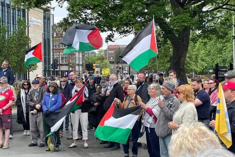 Group of a few dozen people with Palestine flags