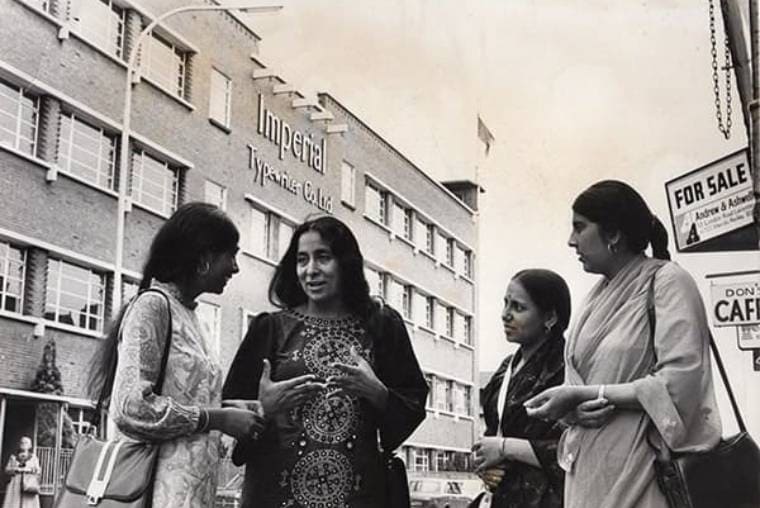 Group of Asian women workers with Imperial typewriters building in the background