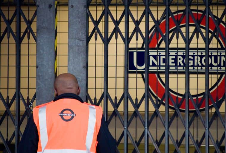 Fermé une porte souterraine londonienne avec travailleur noir devant
