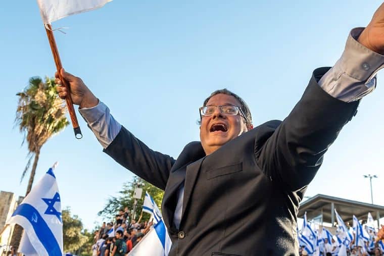 Itamar Ben-Gvir shouting and waving an Israel flag