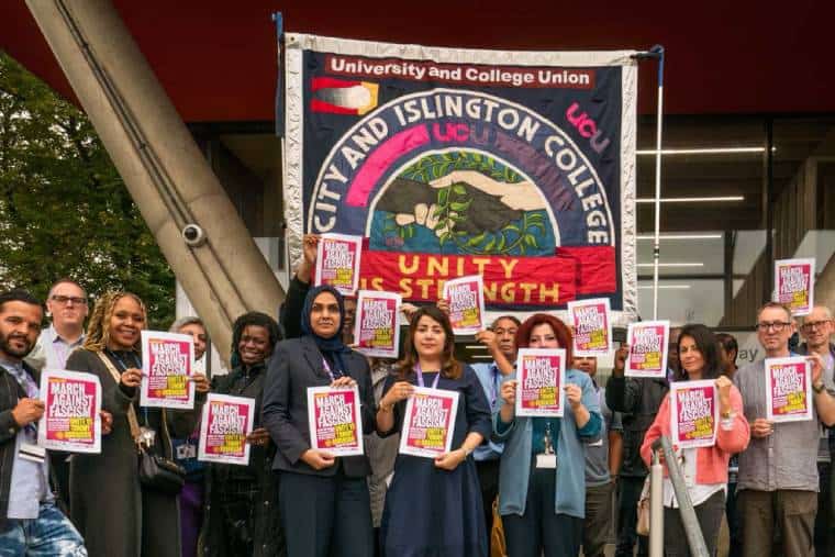 Groupe de syndicalistes avec une bannière de succursale détenant des affiches antiracistes avec beaucoup de femmes impliquées