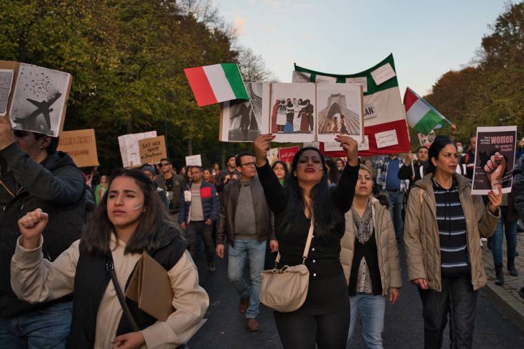 Women marching with pictures of Iranian women