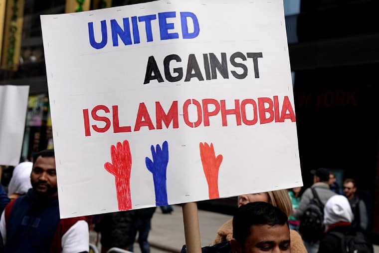 A man holds up a sign with the words