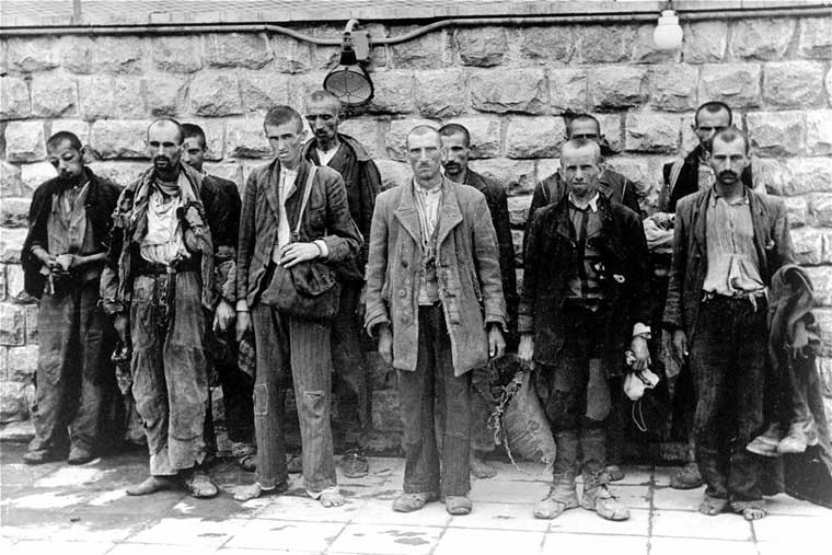 Un groupe d'hommes portant des vêtements déchirés et en lambeaux se préparant à être admis comme prisonniers dans le camp de concentration de Mauthausen en Autriche